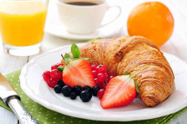 Eine Tasse Kaffee zum Frühstück mit einem Croissant