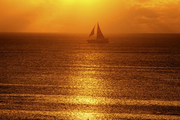 The ship sails into the sea at sunset