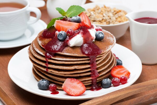 Pancakes with jam, blueberries, strawberries and mint