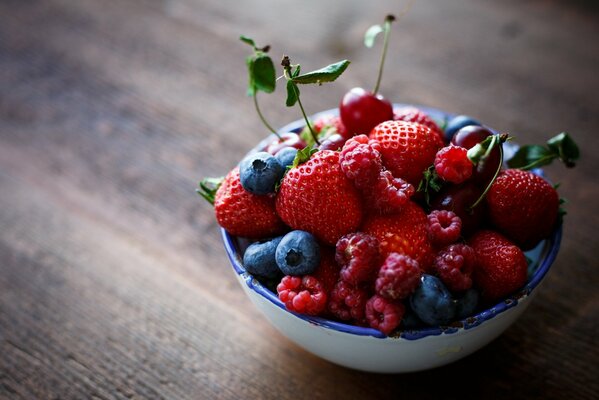 Teller mit Erdbeeren, Himbeeren und Blaubeeren auf dem Tisch