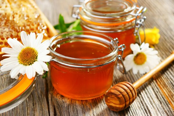 Jars of flower honey with a spoon