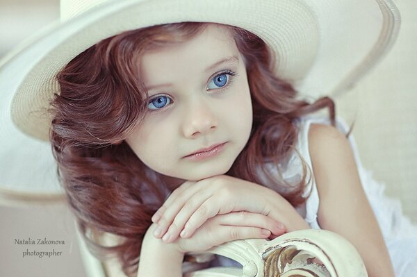 Belle fille aux yeux bleus. Bébé au chapeau