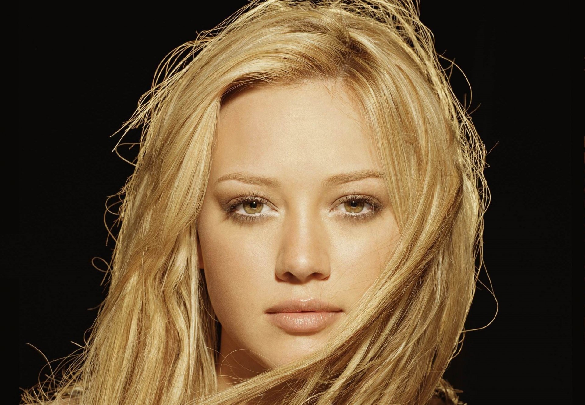 hilary duff chica actriz cara mirada rubia ojos marrones labios fondo negro