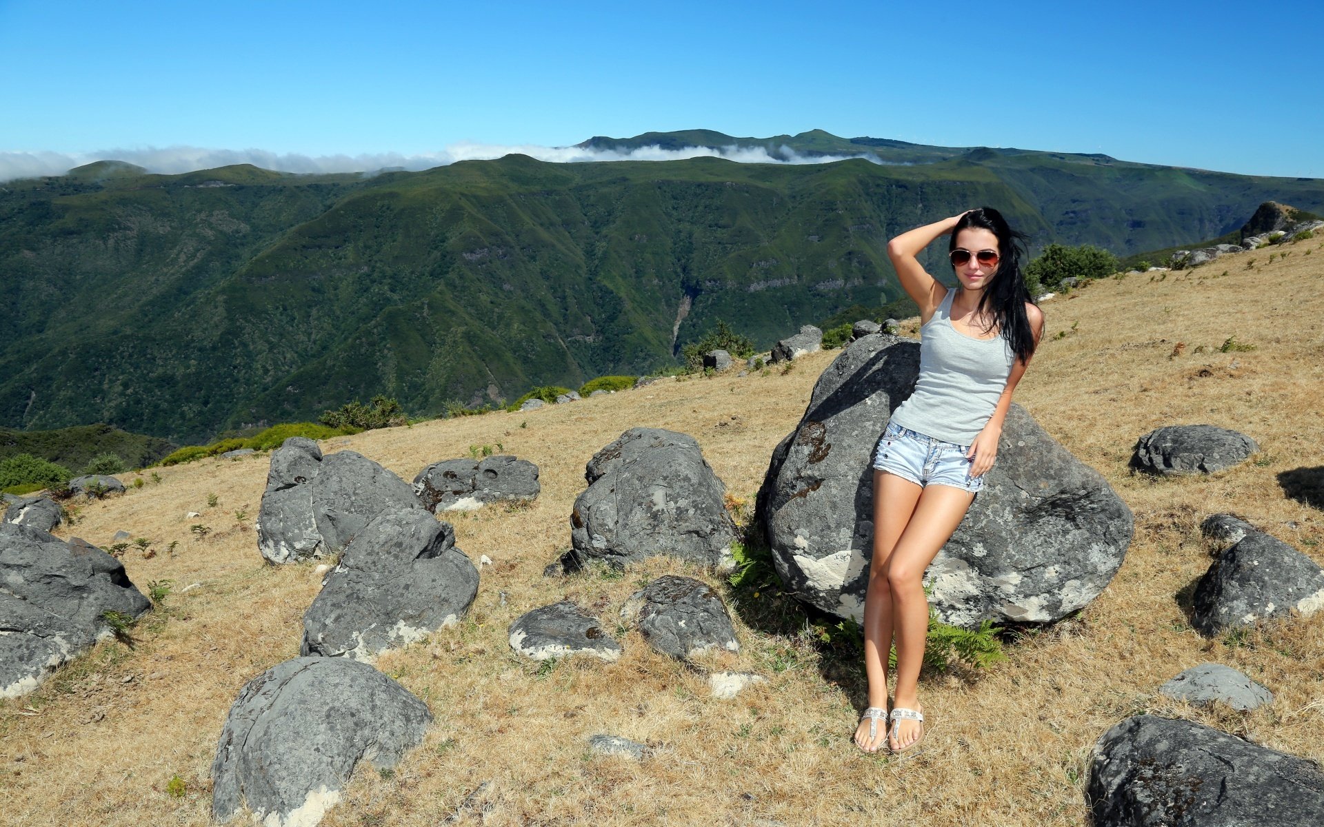 chica morena piernas pose montañas piedras cielo