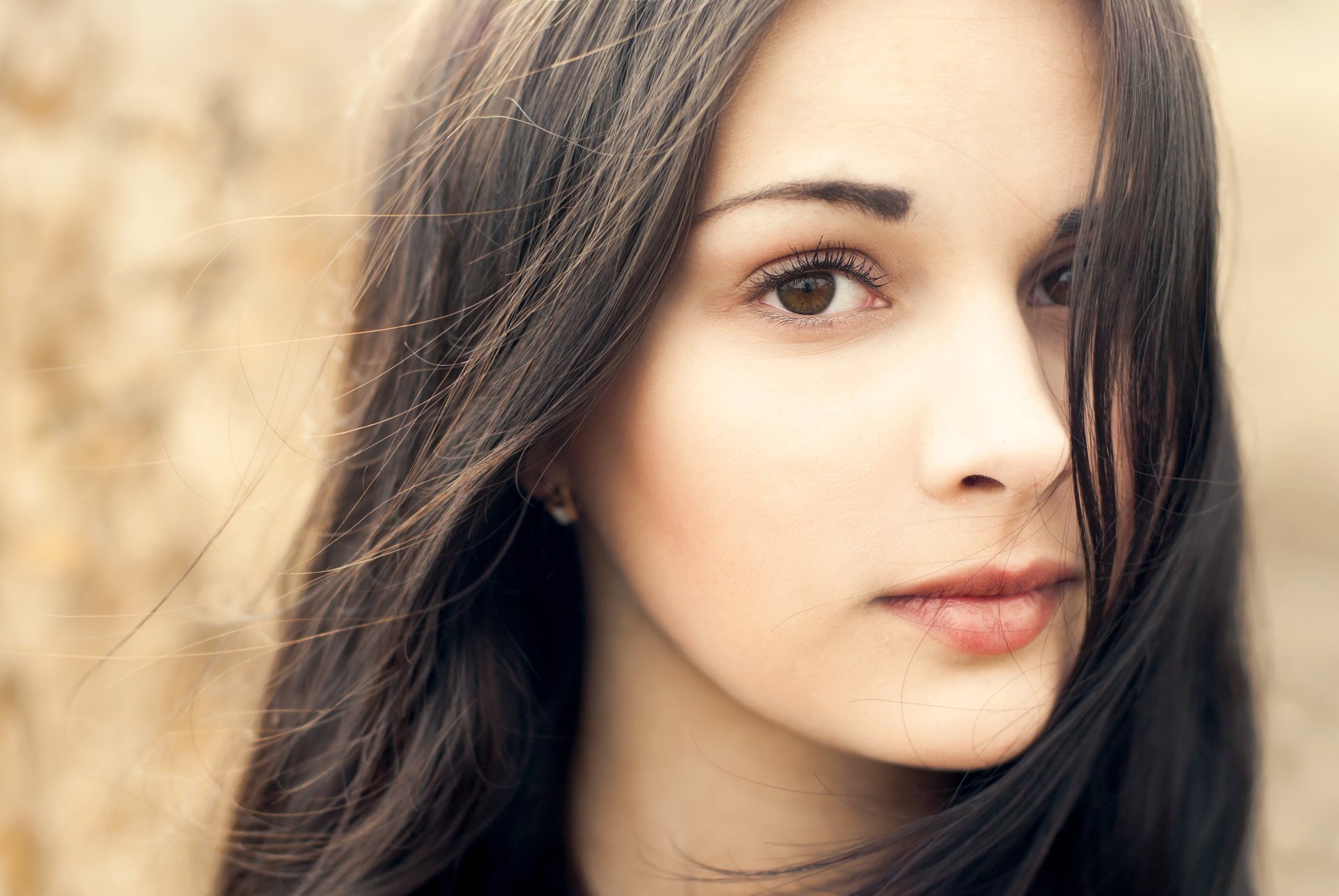 ragazza bella sguardo occhi marroni viso labbra. capelli orecchini sfondo