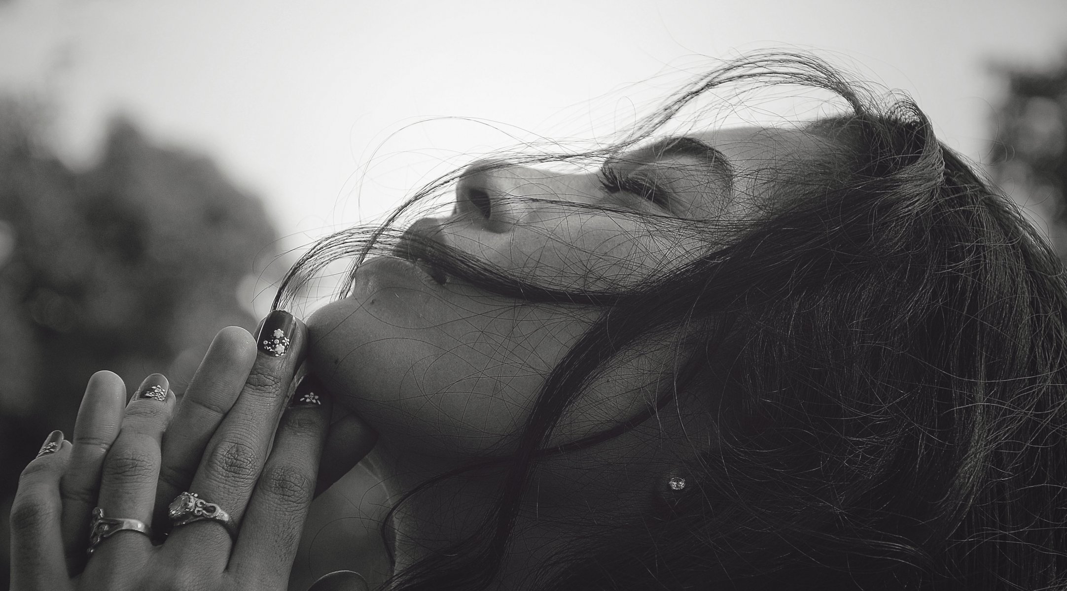 chica blanco y negro cara perfil ojos cerrados cabello manos anillos manicura