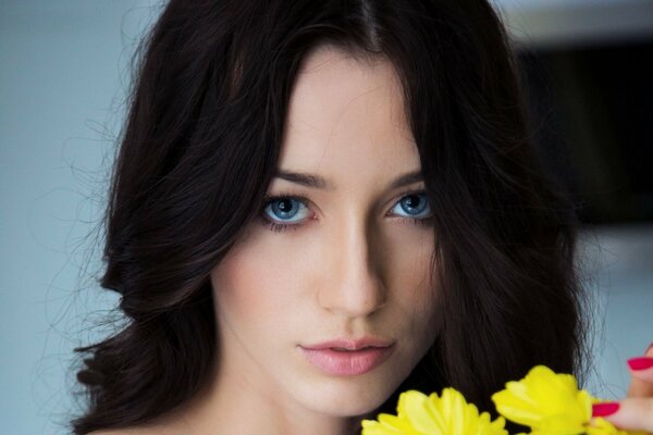 Fille avec des fleurs jaunes et des yeux bleus