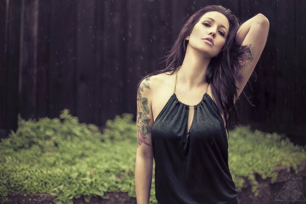 Modell im Regen. Mädchen in Tattoos