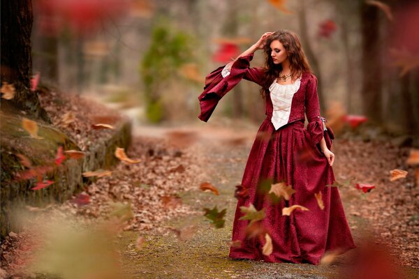 Mysteriöses Mädchen im roten Kleid im Herbst