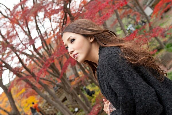 Long-haired Asian woman in the autumn park