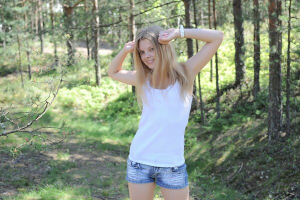 2015 models. A girl in shorts and a white T-shirt. Young girl in nature