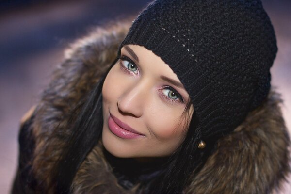 Brunette dans un chapeau noir et une veste avec de la fourrure