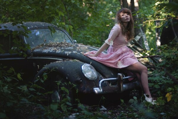 Ragazza romantica su un auto retrò abbandonata nella foresta