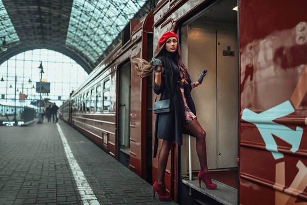 Fille dans un béret rouge entre dans le wagon