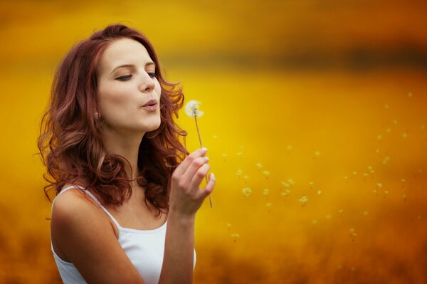 A red-haired girl with a dandelion. Beautiful photos of girls