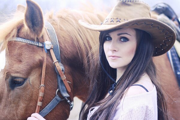 Brunette au chapeau avec un cheval