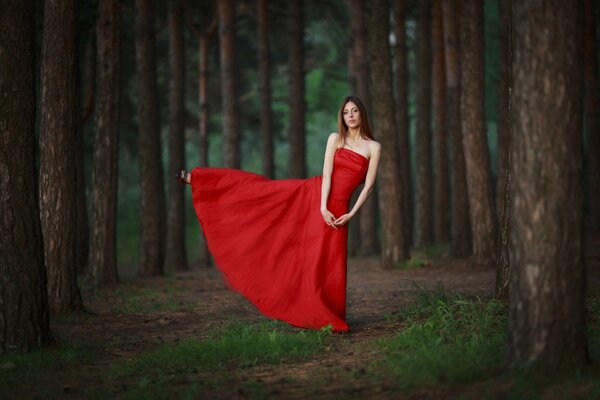 A girl in a red dress in the forest