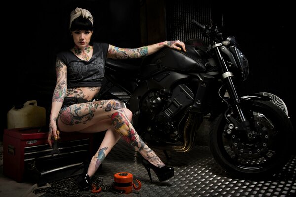 Chica con tatuajes en moto