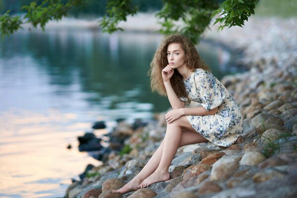 Fille aux yeux bruns dans une robe sur les pierres