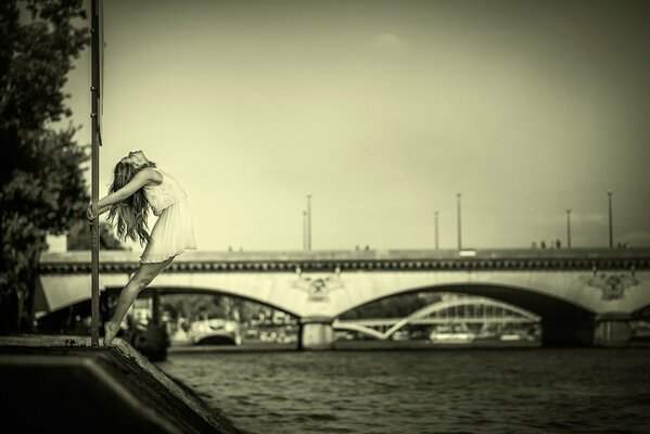 Photo of a graceful girl on the background of a bridge