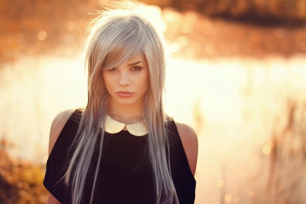 Blonde with long hair and wearing a black sweatshirt