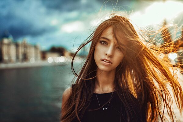 Retrato de una niña en los rayos de una puesta de sol dorada