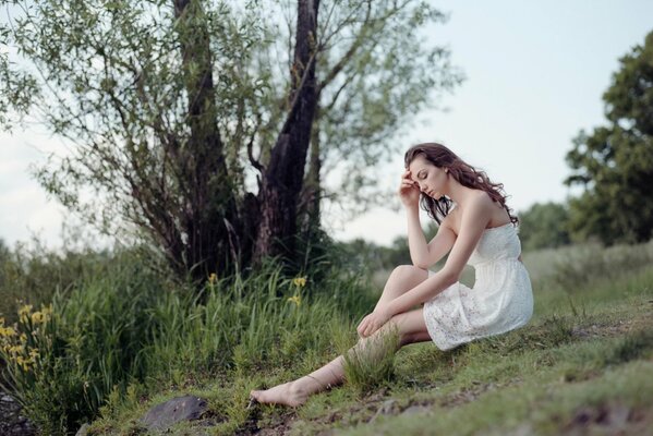 Foto di una ragazza in un abito bianco nella natura