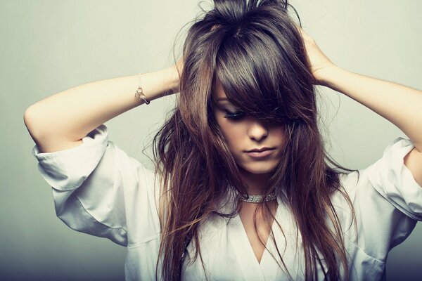 Foto di bellezza di una ragazza che ha raccolto i capelli nei palmi delle mani