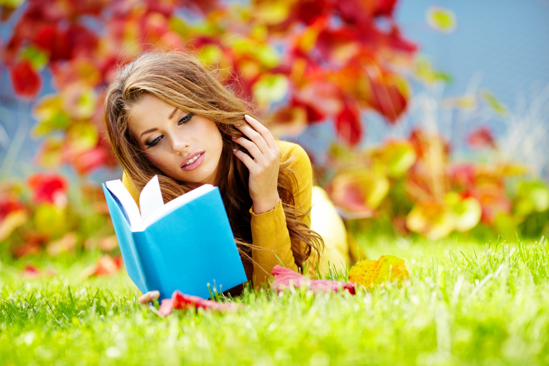 fille brune livre parc herbe feuilles automne