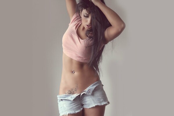 Ragazza con tatuaggio e piercing per un servizio fotografico