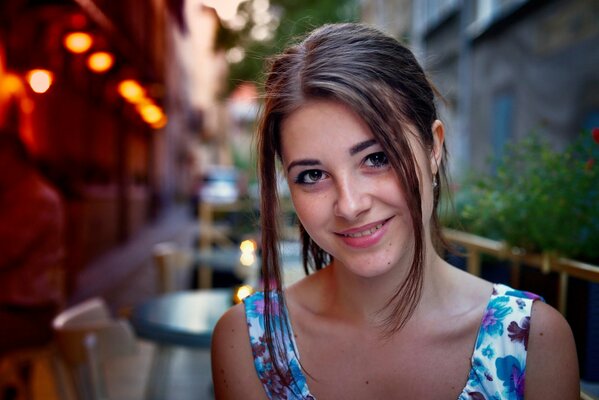 Jolie fille aux yeux bruns souriant sur fond de café