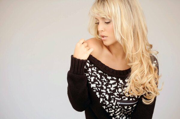 Blonde à l épaule dénudée dans un pull noir