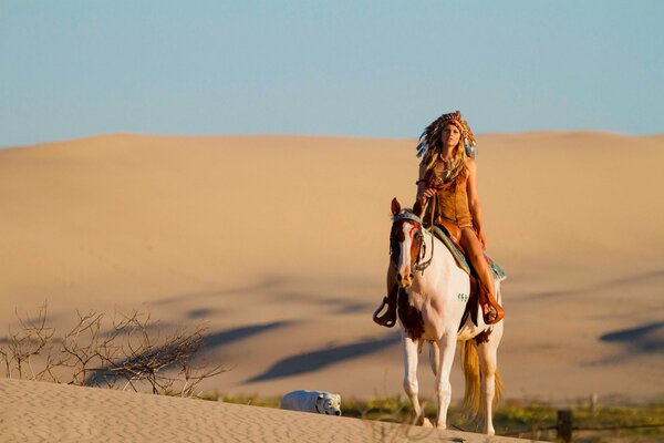 Kavboika on horseback in the desert with a dog