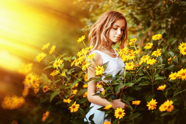 Ragazza in canotta bianca tocca i fiori