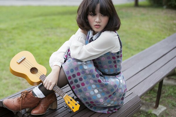 Ragazza asiatica con la chitarra in mano