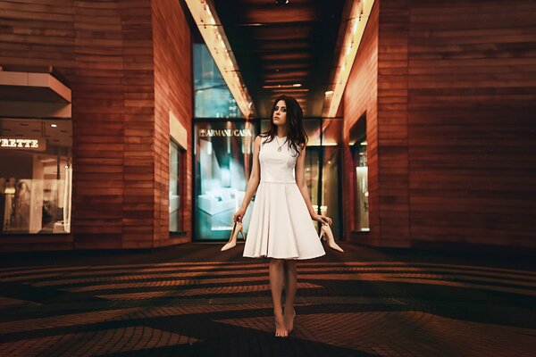 Ragazza bruna in abito bianco con le scarpe