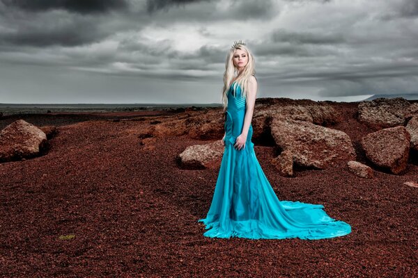 A girl in a blue dress on the coast of Iceland