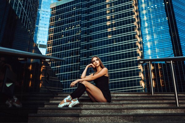 Ballerina in pointe shoes on the steps of Moscow City