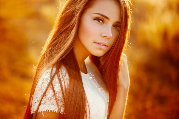 Fille de cheveux roux sur fond de soleil