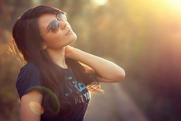 Brunette à lunettes sur fond d éblouissement du soleil