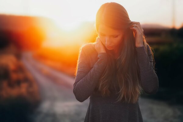 Chica pensativa en el fondo de la puesta de sol