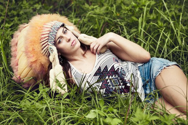 A girl in an Indian headdress on the grass