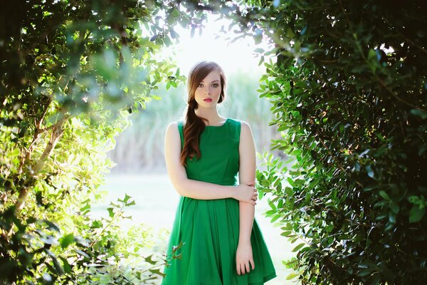 A girl in a green dress against the background of nature