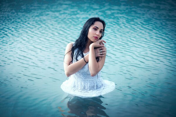 Chica con vestido de pie en el agua