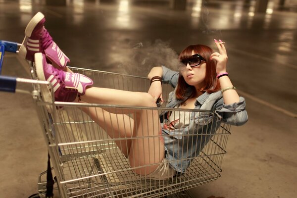 A girl of Asian appearance is sitting in a grocery basket