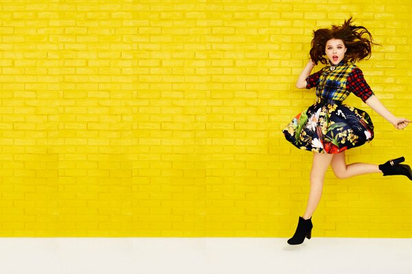 Actress Chloe Moretz on the background of a yellow wall