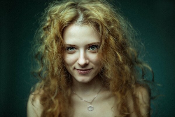 Fille Rousse avec de beaux yeux et un sourire mystérieux