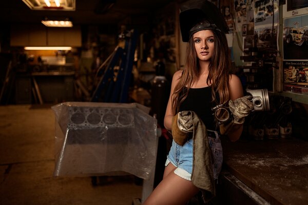 A girl in a car service posing with overalls