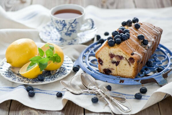 Cupcake, mit Blaubeeren, Zitrone und einer Tasse Tee