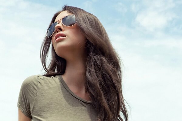 A young girl with long hair in shadow glasses